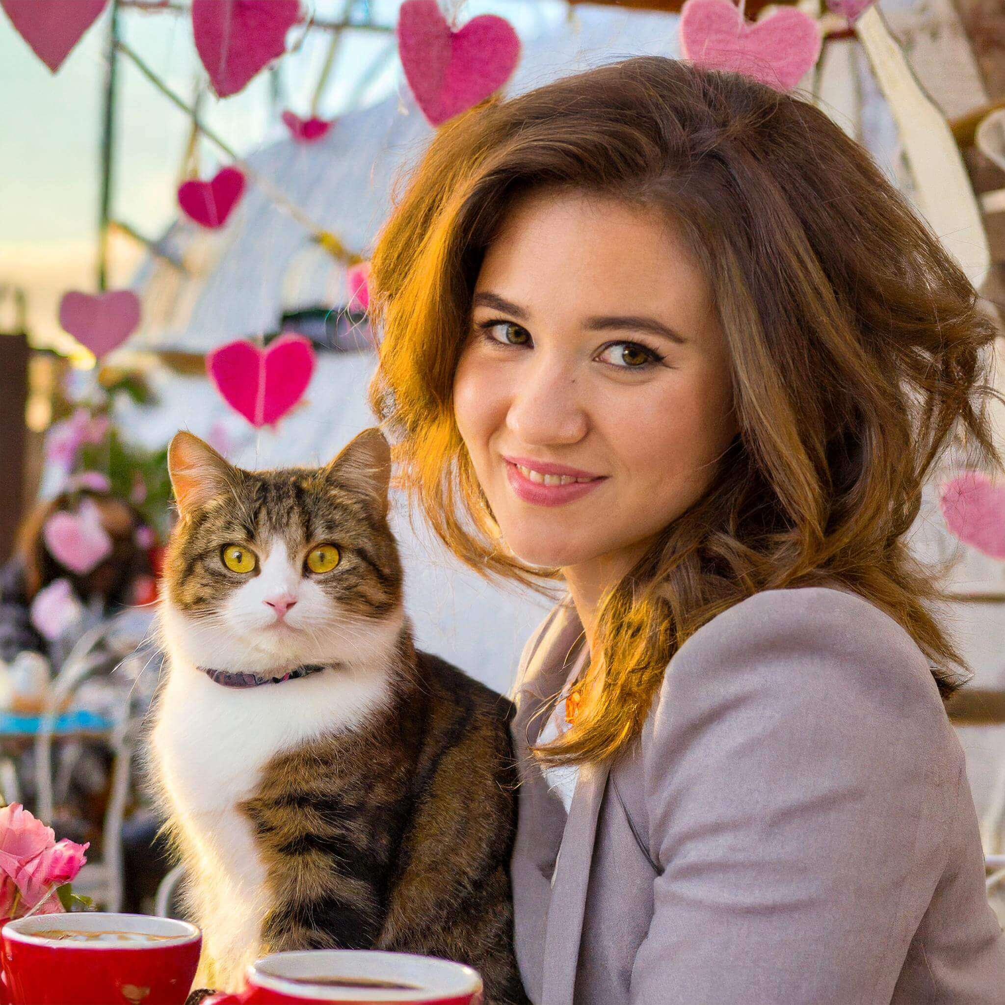 Woman celebrating Valentines day at Kitty Kisses Cafe with a cat